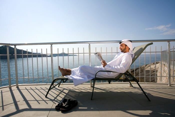 muslim na terase u moře čte noviny