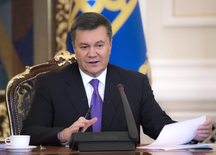 Janukovyč hovořící u stolu s mikrofonem